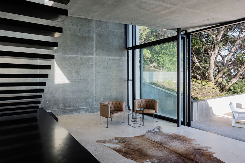 Голые бетонные стены сочетаются с полом из травертина, чтобы создать стильный современный вид в этом новозеландском доме 