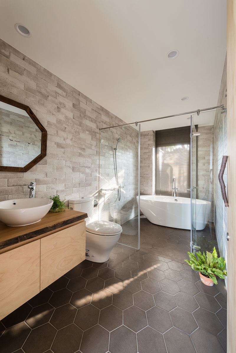  В этой современной ванной комнате стеклянная перегородка отделяет душ и отдельно стоящую ванну от унитаза и раковины. # ВаннаяДизайн # Современный 