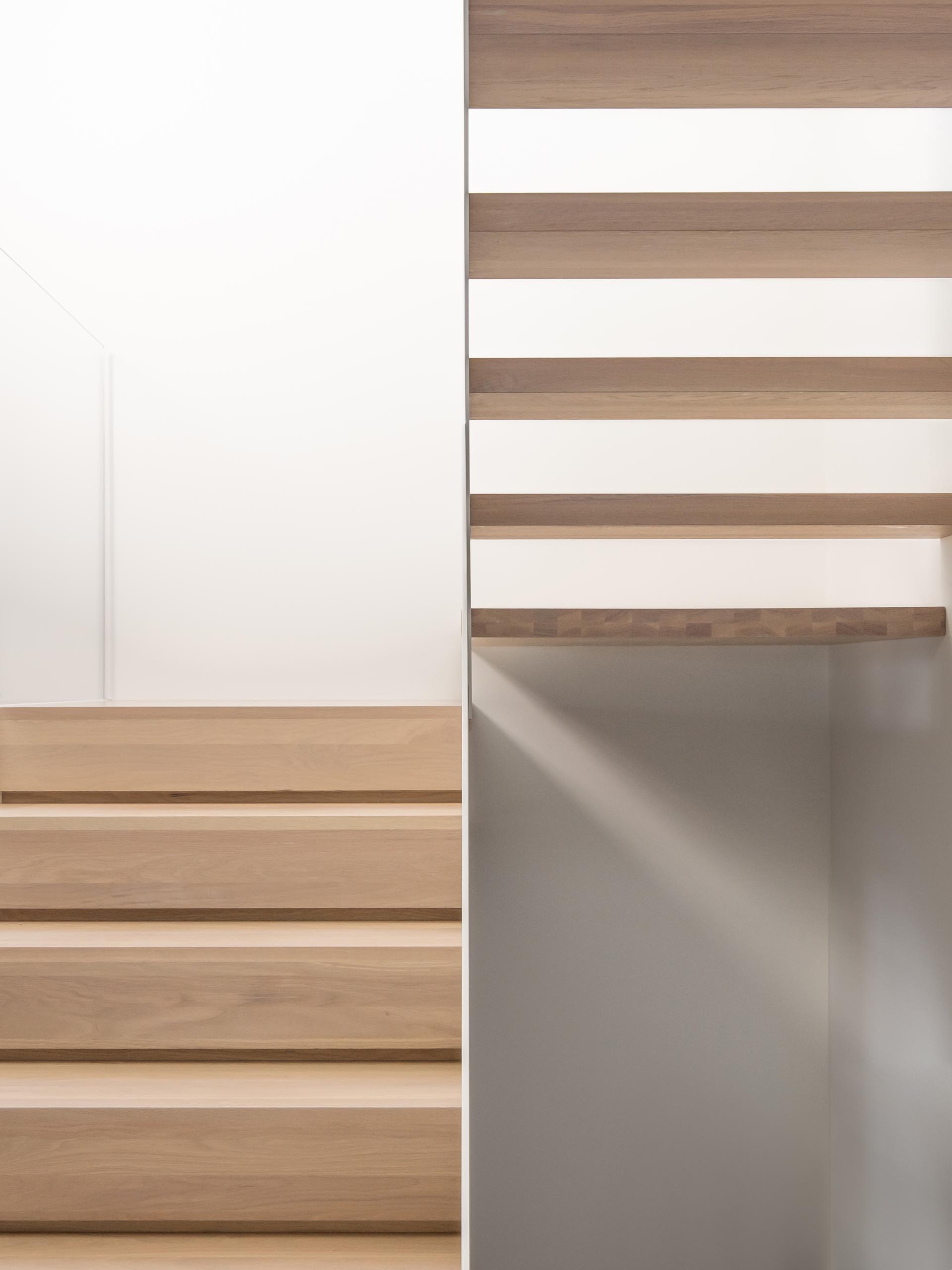 Современная белая лестница с деревянными ступенями.