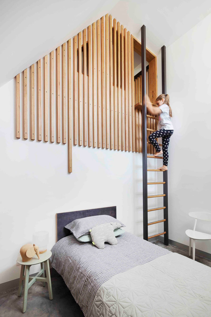  В этой современной детской спальне есть чердак, на который можно подняться по лестнице, причем чердак частично скрыт деревянными рейками. 