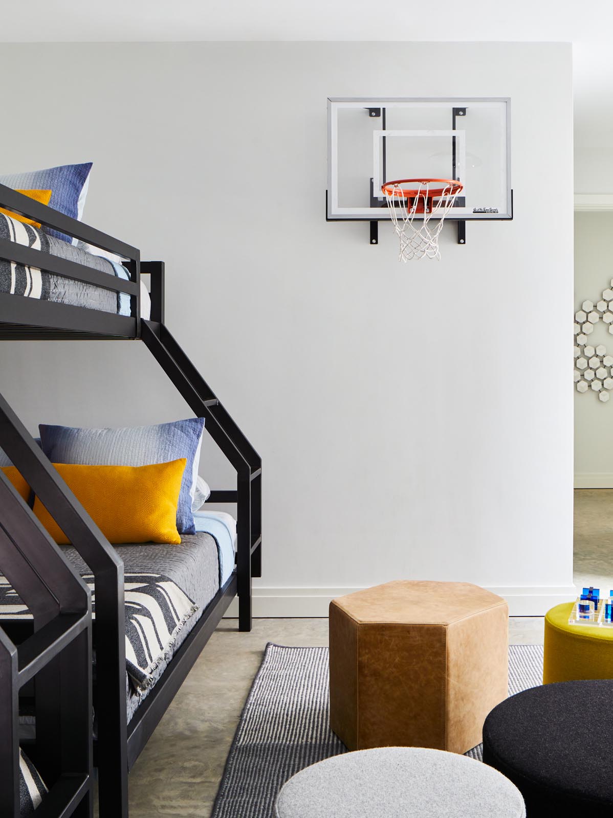 Детская спальня с двухъярусными кроватями и баскетбольным кольцом.