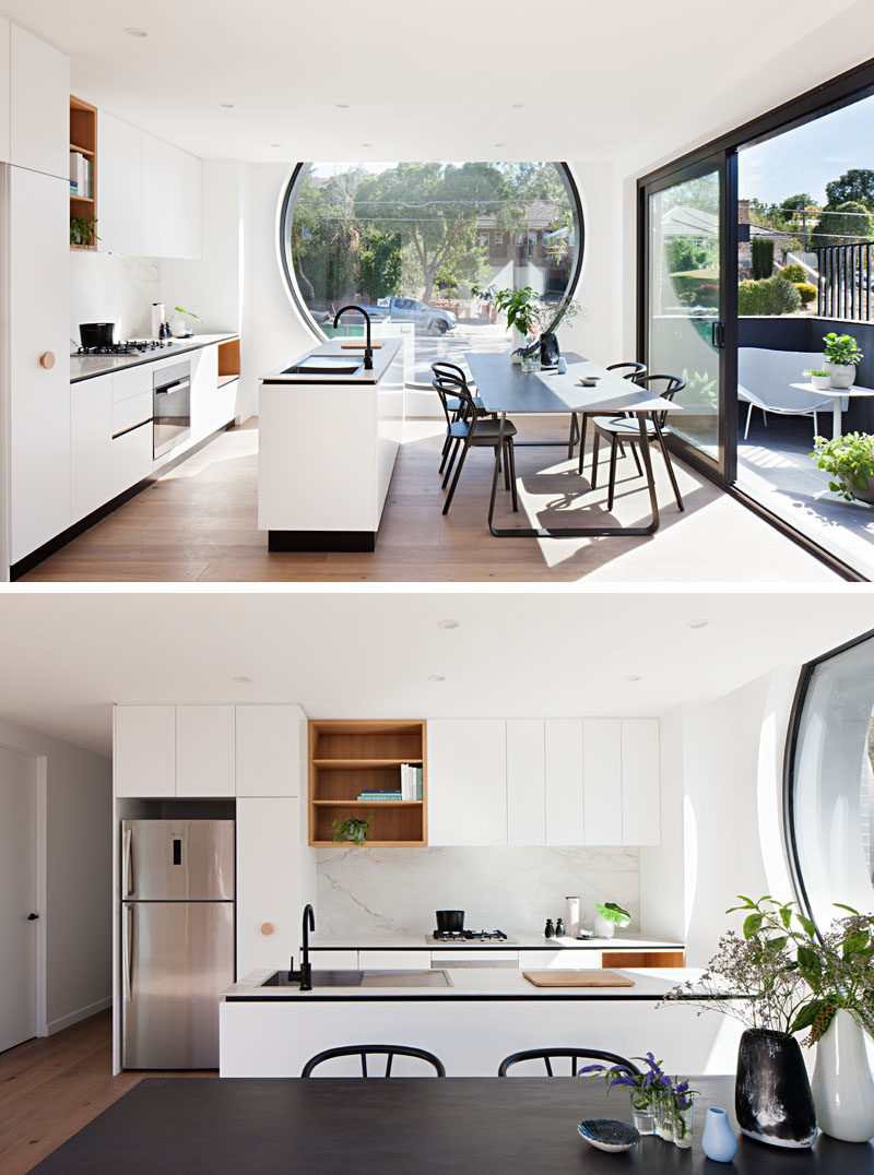  Эта кухня имеет минималистичный дизайн, с длинным островом, разделяющим и разделяющим стену кухонных шкафов. Открытые деревянные стеллажи разбивают все белые шкафы, а большое окно-иллюминатор наполняет комнату естественным светом. # Кухня # Современная кухня # Белые кабинеты # Столовая # ИнтерьерДизайн 
