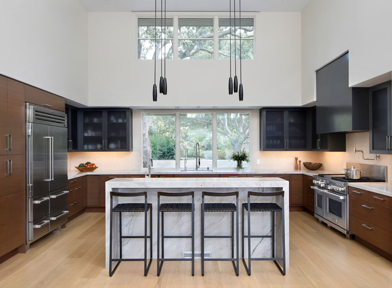 В этой современной кухне палитра отражает цвета и материалы, используемые для экстерьера дома. Мраморные столешницы сочетаются с окрашенными нижними шкафами, которые соответствуют современному деревянному сайдингу дома, в то время как темно-серый капот и верхние шкафы сочетаются с внешними металлическими элементами. ModernKitchen #KitchenDesign 