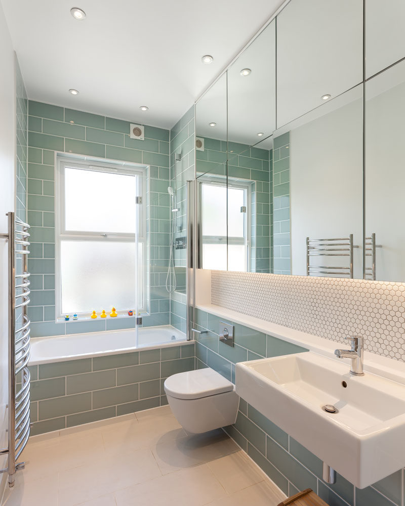  В современной ванной комнате светло-зеленая плитка метро сочетается с белой плиткой-пенни и большой группой зеркал. # Зеленая плитка # Современная ванная # Дизайн ванной 