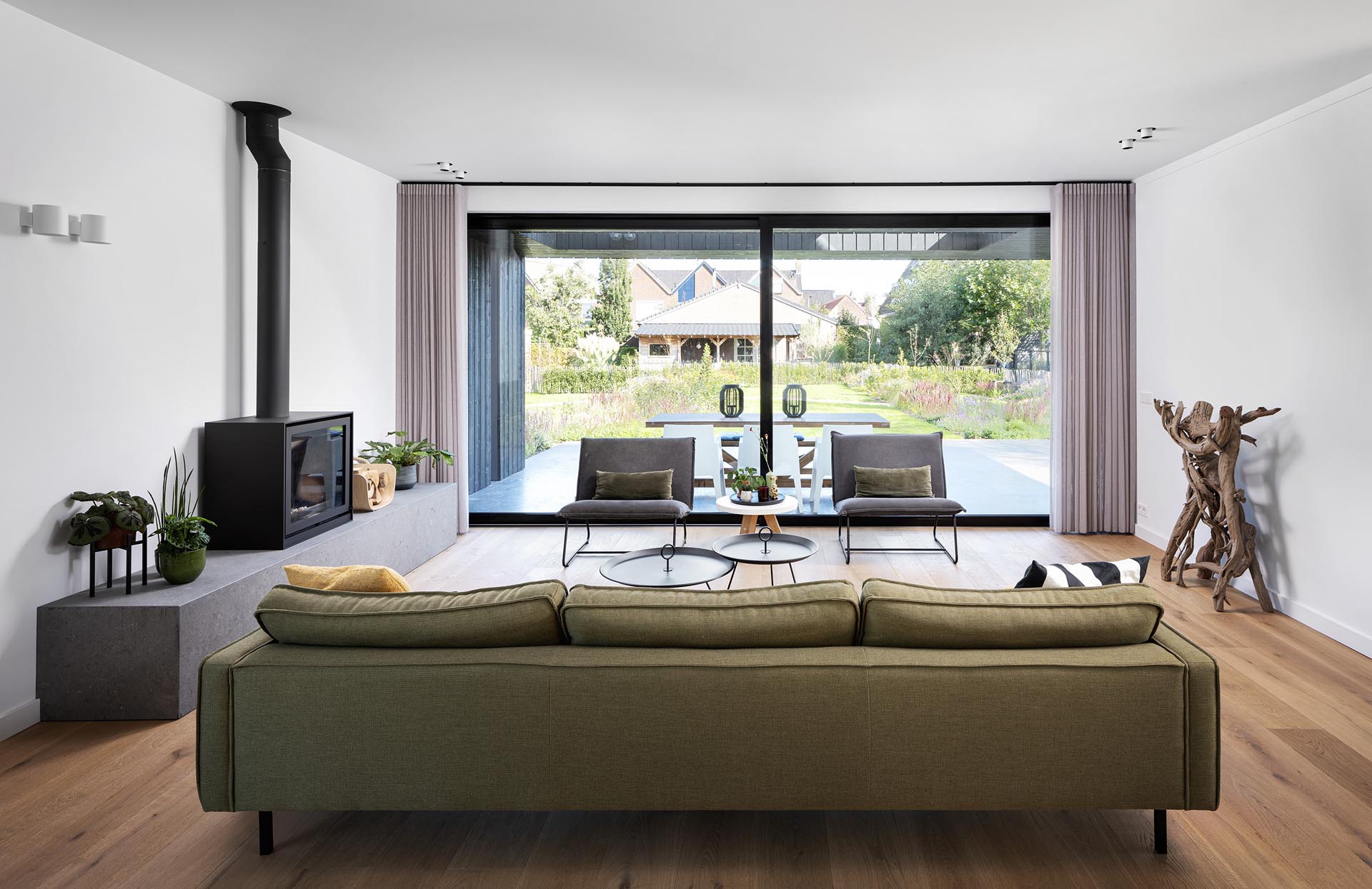 Внутри современного дома мебель сохранена в минималистичном стиле, а большие раздвижные двери открывают гостиную на открытый патио, предназначенный для обедов на свежем воздухе.