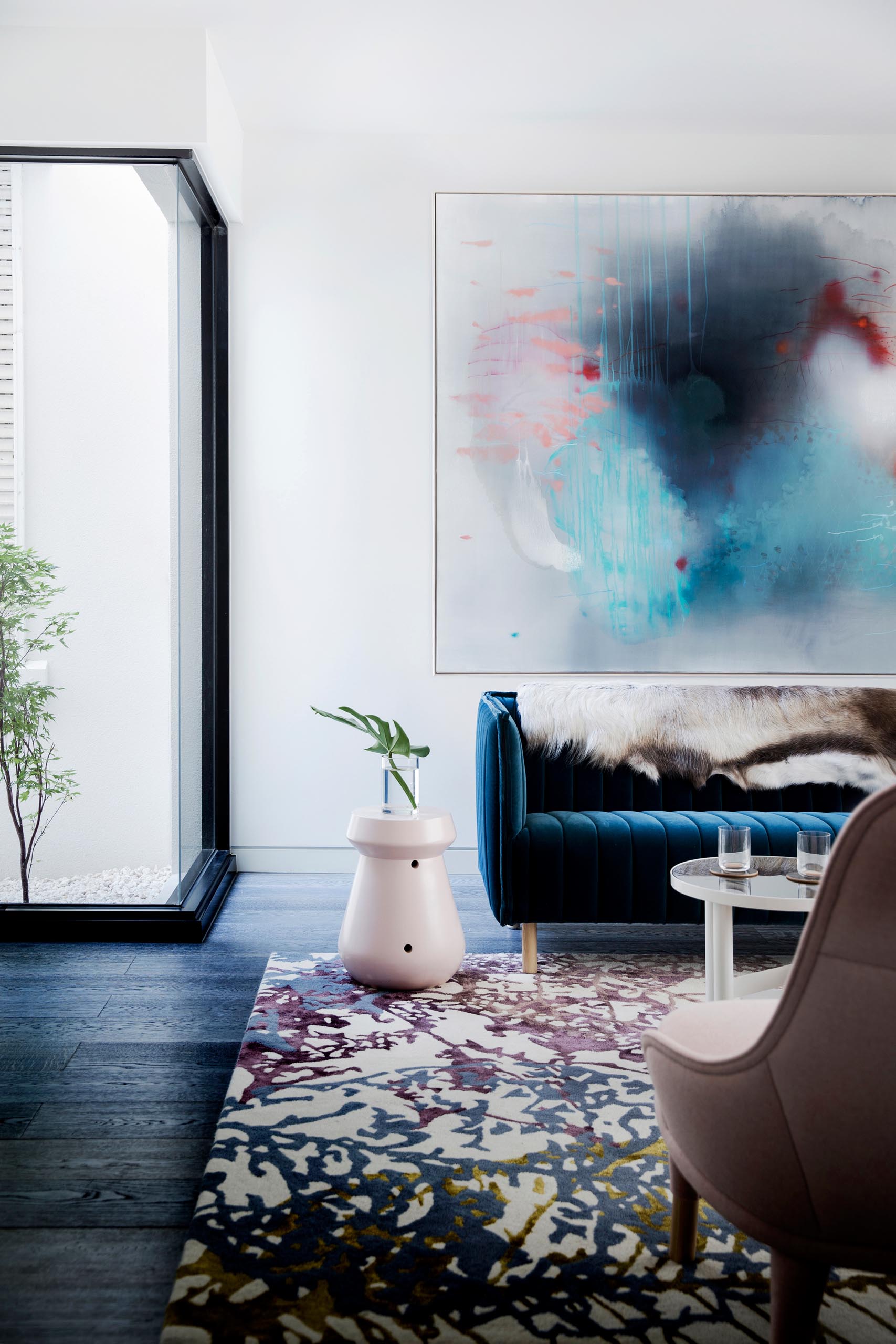 Современная гостиная с голубыми и румяно-розовыми элементами мебели.