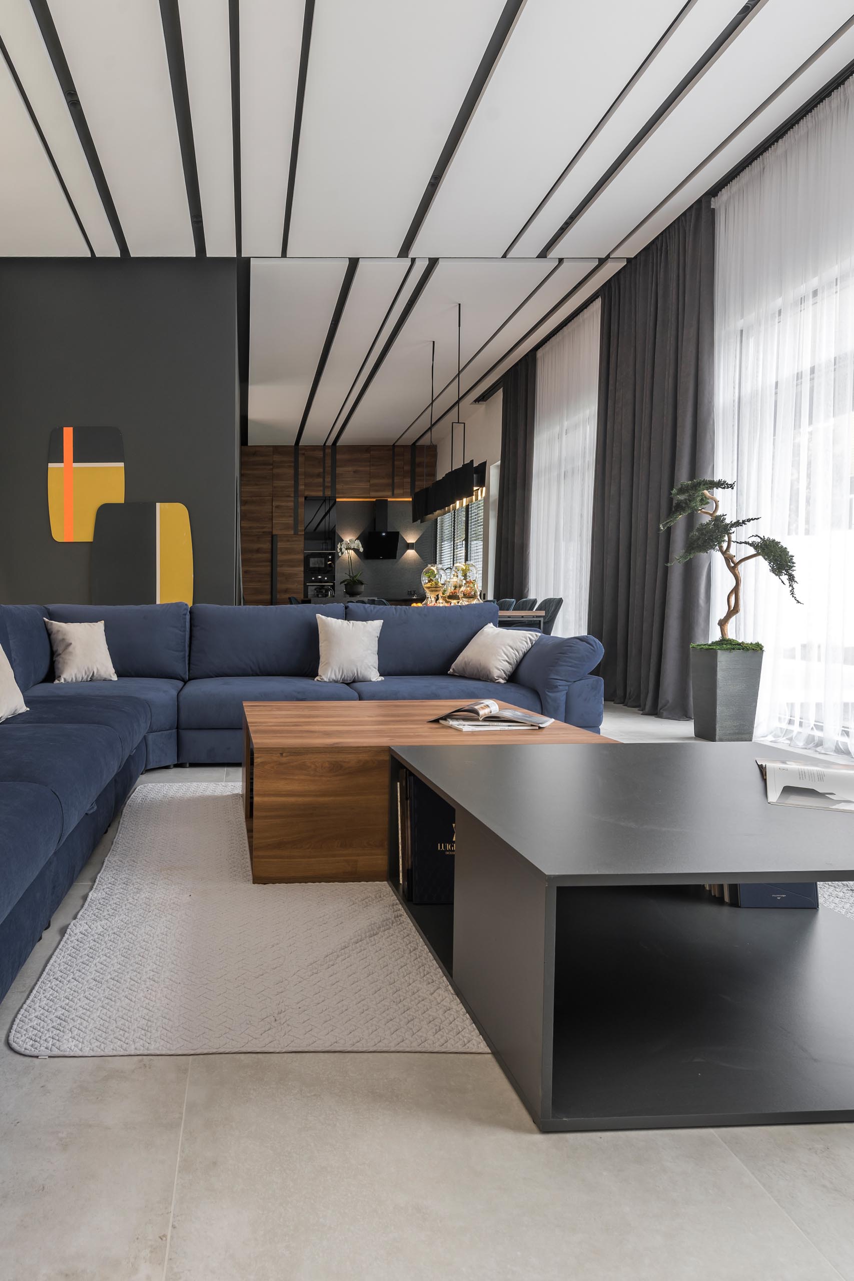 Современная гостиная с большим синим диваном и журнальным столиком из дерева и серого цвета.