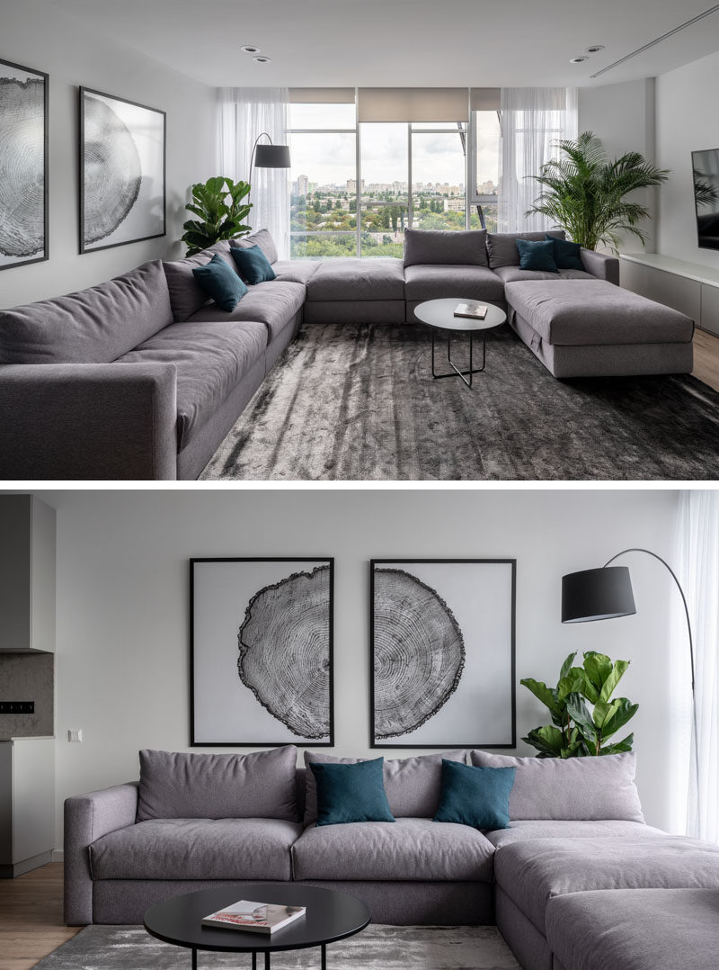 Идеи для гостиной - в этой современной гостиной темно-синие стулья и диванные подушки добавляют небольшой оттенок цвета к скромной бело-серой палитре, в то время как растения и деревянные элементы, такие как пол и художественные принты, добавляют дыхание природы всему целому. Космос. #LivingRoomIdeas #LivingRoomDesign #ModernLivingRoom