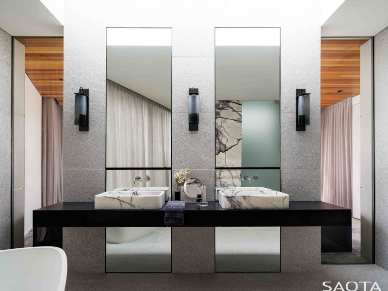  В этой современной главной ванной комнате есть черный туалетный столик с каменными раковинами, два высоких зеркала отражают свет в комнате. # МастерВанная # СанузелВанная 
