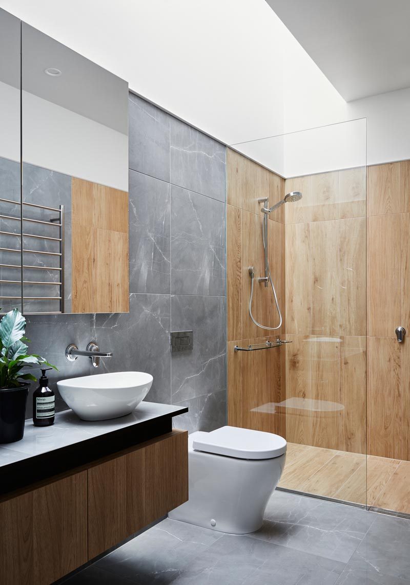 В этой современной ванной комнате потолочное окно украшает пространство и подчеркивает деревянную плитку в душе и серую плитку в остальном пространстве. # ВаннаяДизайн # Современный