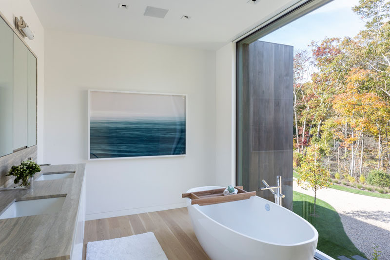 В этой современной главной ванной комнате отдельно стоящая ванная расположена перед большим окном, что в комнате много естественного света. # Современная ванная # Дизайн ванной