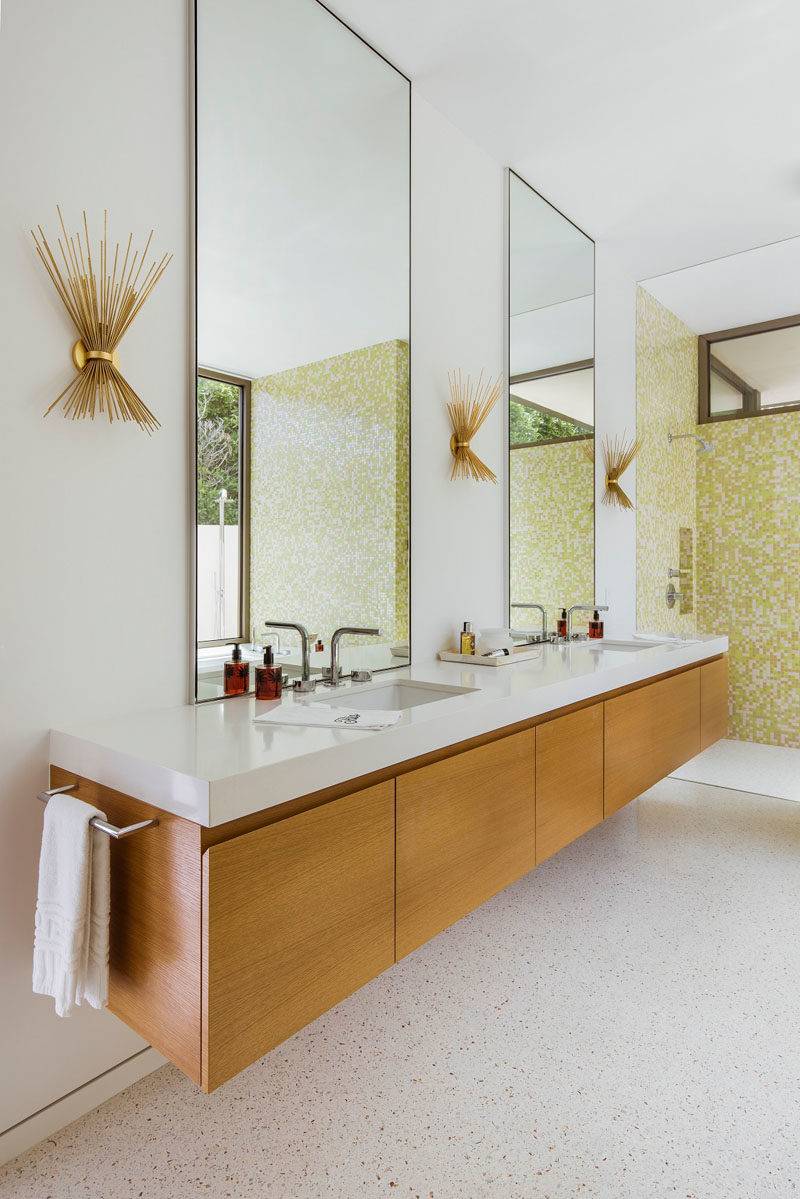 В этой современной главной ванной комнате высокие зеркала отражают свет снаружи, а изящные бра отражают дизайн дома середины века. # Современная ванная # Дизайн ванной # Идеи для ванной
