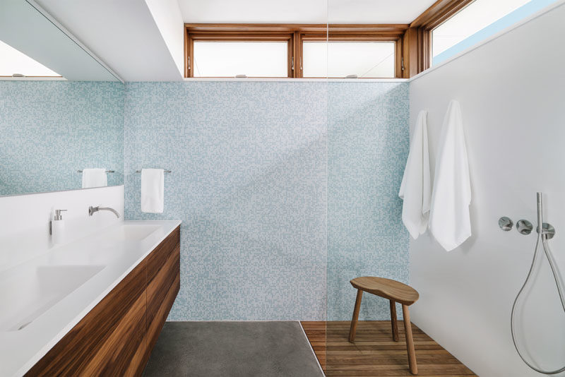 Идеи для ванных комнат - В этой современной ванной комнате минималистичный деревянный туалетный столик со встроенными раковинами выстилает стену, в то время как плиточная стена добавляет мягкое прикосновение цвета, а окна на потолке пропускают естественный свет. #BathroomIdeas # VanityIdeas # ModernBathroom