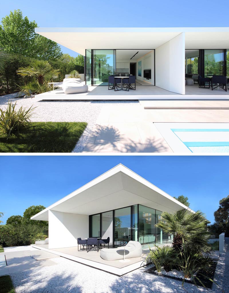 Белый дом в стиле минимализма с крытыми патио и стеклянными стенами.
