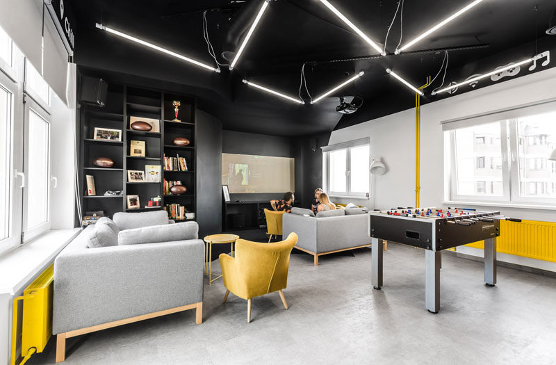 В этой современной офисной комнате для отдыха с потолка свисают зигзагообразные лампы, а желтые элементы мебели перекликаются с молнией на логотипе компании.