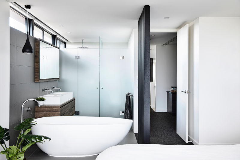 В этой современной спальне ванная комната находится внутри комнаты и является открытой, с закрытыми дверями только душ и туалет. # Ванная # МодернСпальня