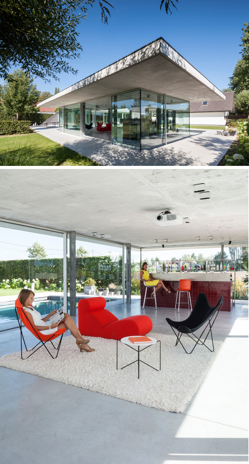 Этот современный бетонный дом у бассейна, окруженный стеклом, обеспечивает прекрасный вид на улицу. Бар, выложенный красной плиткой, и уютные кресла делают это место отличным местом, чтобы выпить после купания в бассейне.