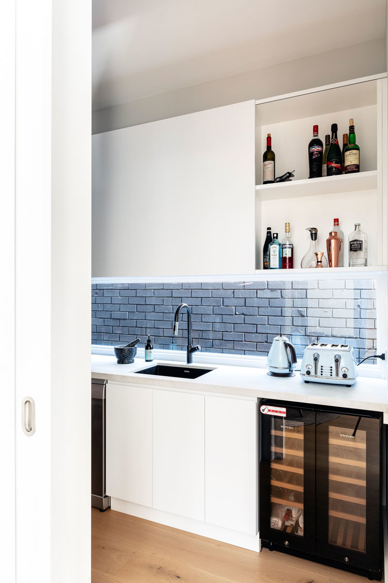Идеи кладовой - эта современная кухонная кладовая имеет много места для хранения вещей, раковину, прилавок и барную стойку. #KitchenPantry #PantryIdeas