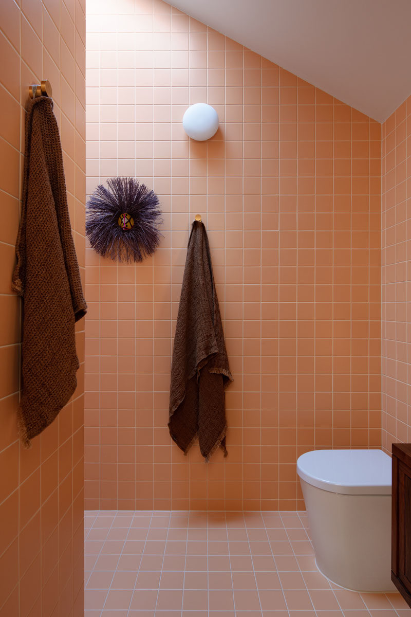 Идеи для ванных комнат - эта современная ванная комната облицована плиткой персикового цвета и имеет угловой потолок. Душ находится за углом, прямо под потолочным окном. # Модерн # Ванная # Идея # Квадратная плитка # Персиковая плитка # Дизайн для ванной
