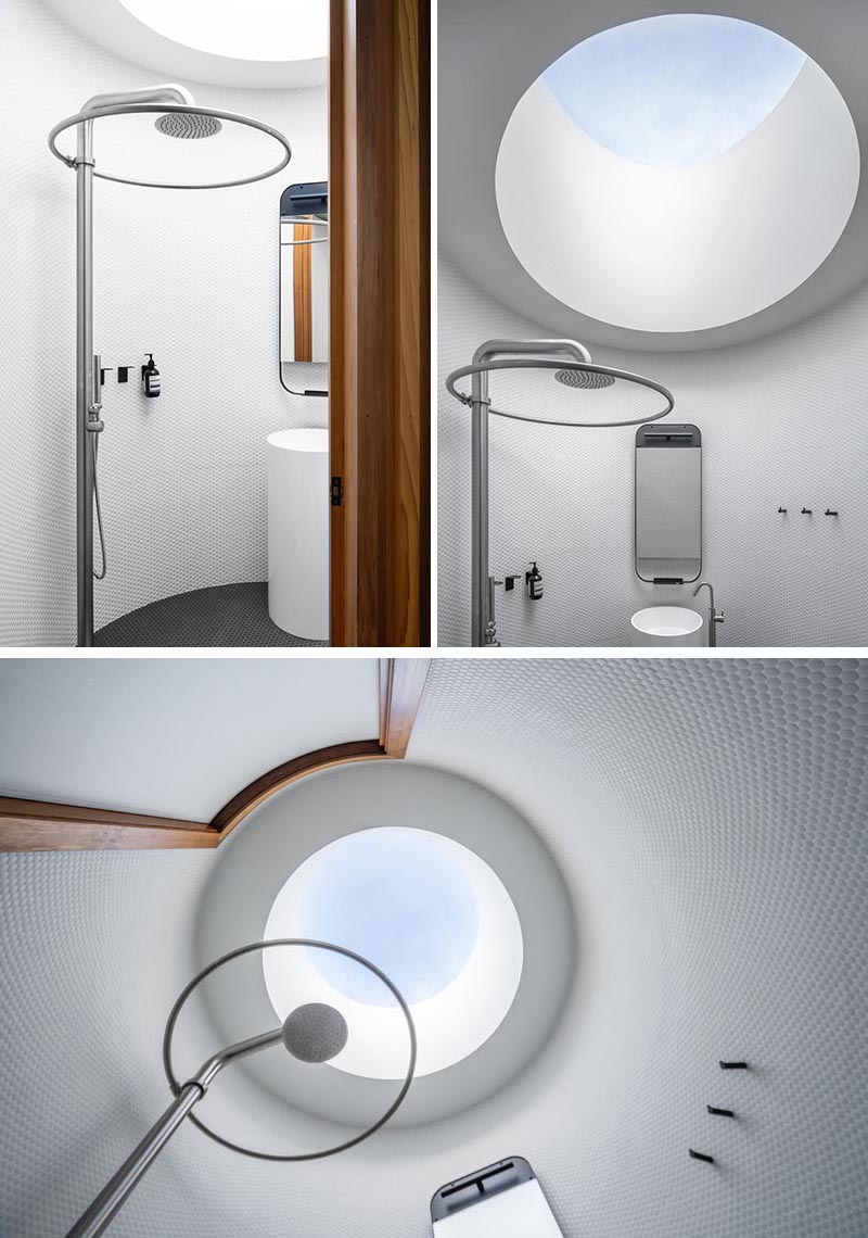 Стены этой современной круглой ванной комнаты выложены белой плиткой, а над душем - круглое окно в крыше, отражающее общую форму ванной комнаты. # Круглый свет # Круглый свет # Ванная # КруглыйВанная # Пенни Плитка