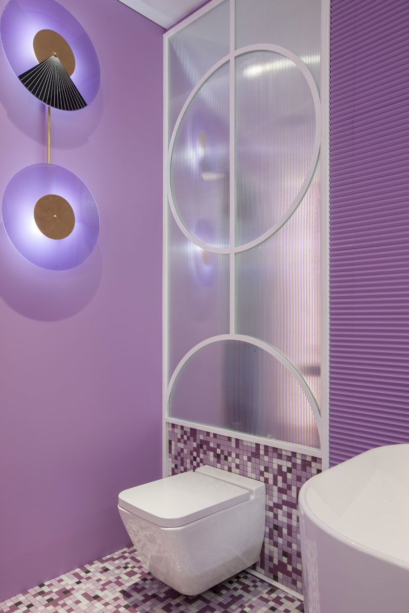 Декоративное настенное освещение является художественным акцентом в этом современном гостиничном люксе, где фиолетовый является основным цветом. #ArtisticLighting #LightingDesign