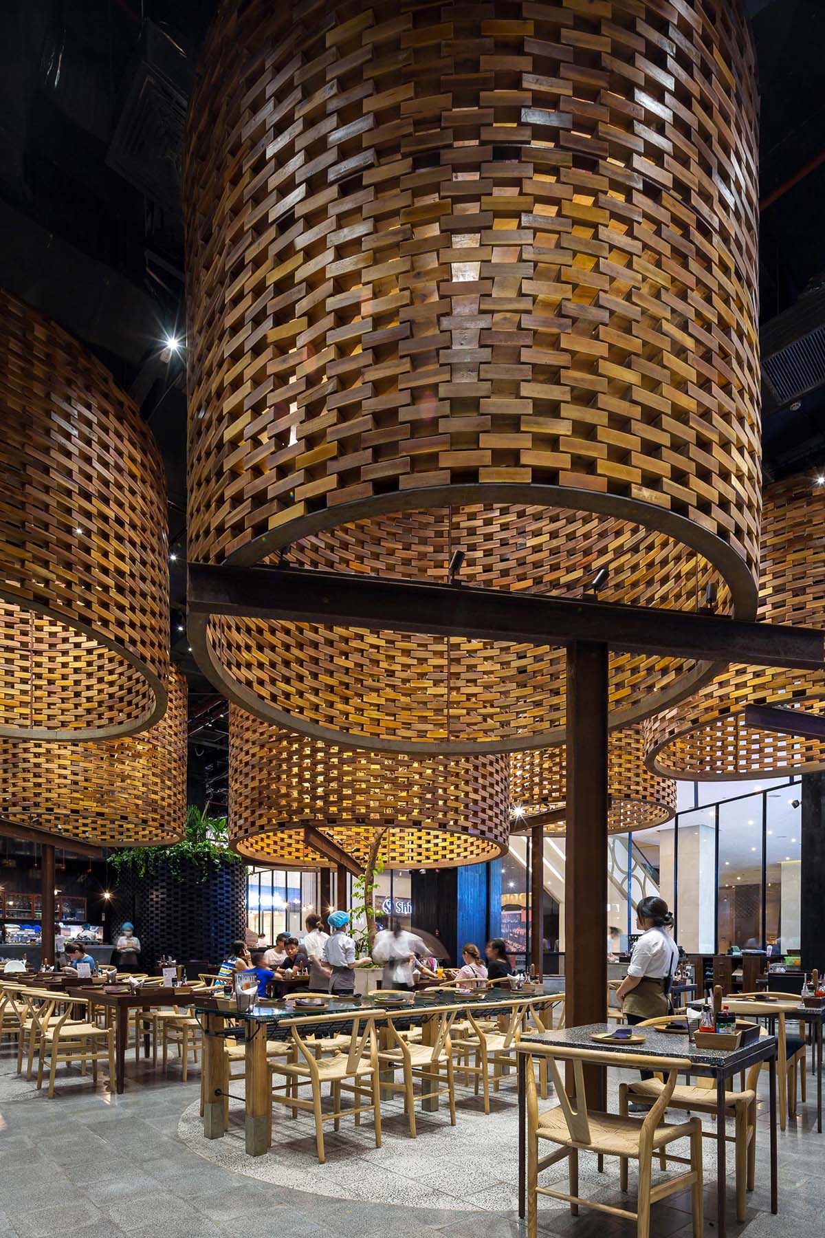 Современный ресторан с большими скульптурными цилиндрами из деревянных кирпичей.