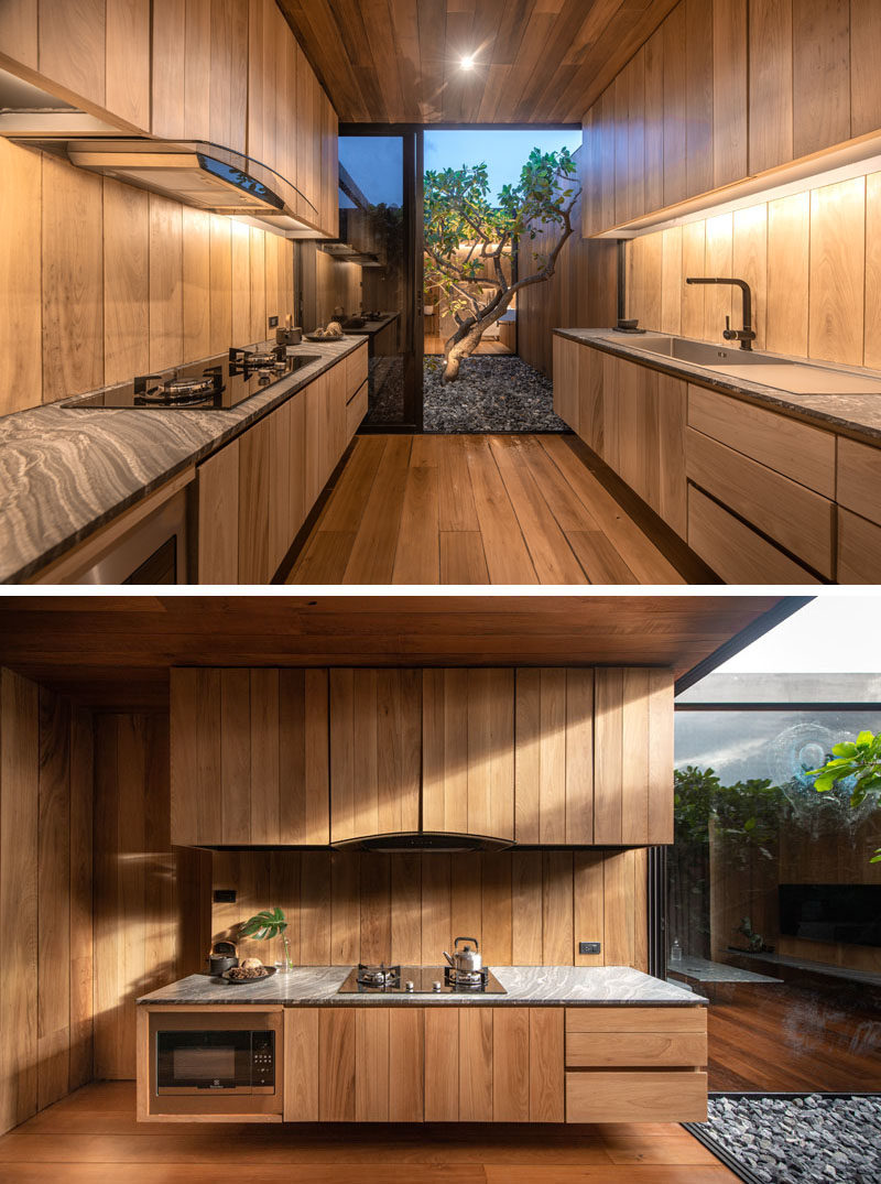 Идеи для кухни - современная кухня с парящими деревянными шкафами и выходом в небольшой двор с деревом. #ModernWoodKitchen #KitchenIdeas # WoodCabinets