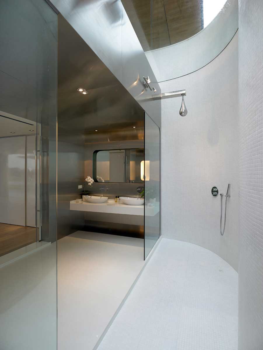 Современная ванная комната со стенами из нержавеющей стали и двойным душем с потолочным окном.