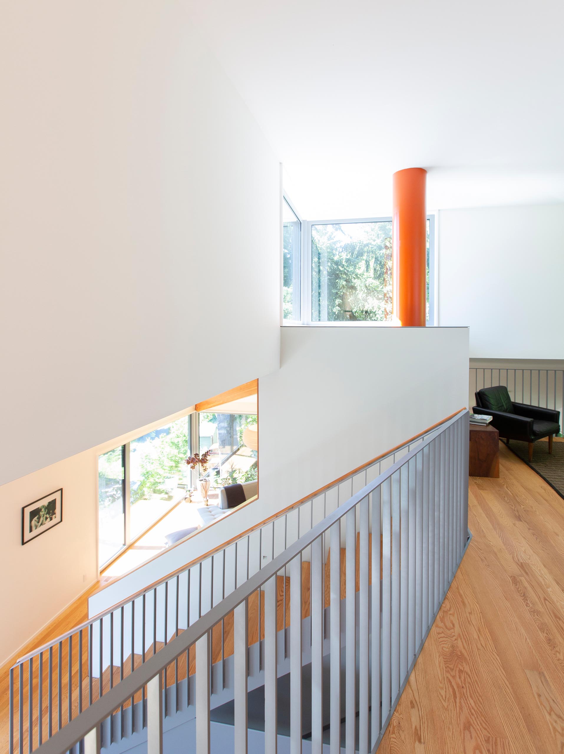Матовые серые и деревянные лестницы соединяют главный уровень этого современного дома с верхним этажом.