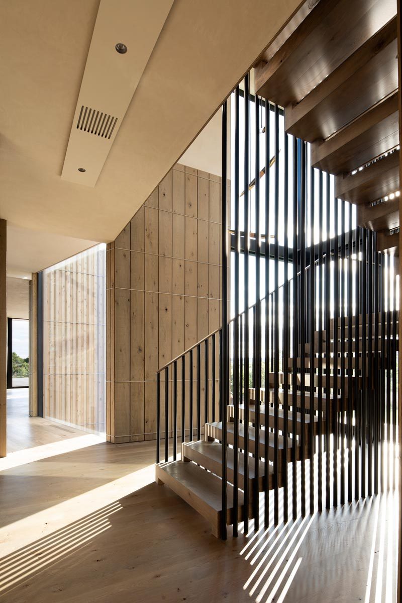 Деревянная и стальная лестница соединяют основной уровень этого дома с верхним. Поручни лестницы играют со светом и отбрасывают в пространство диагональные тени. # Современные лестницы # Стальные поручни # Дизайн лестницы
