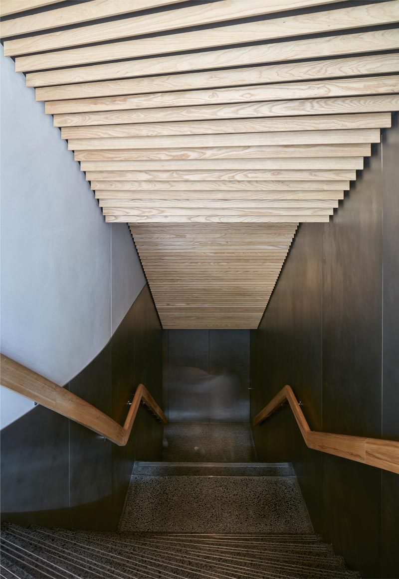 Деревянные планки из ясеня украшают потолок этой современной лестницы в ресторане. # Деревянные плиты # Идеи потолков # Современные лестницы
