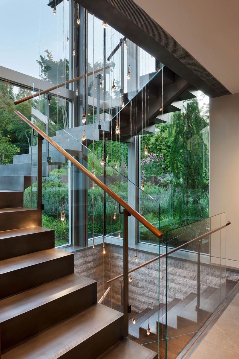 Стальная лестница, окруженная окнами, соединяет разные уровни дома. #SteelStairs #StairDesign
