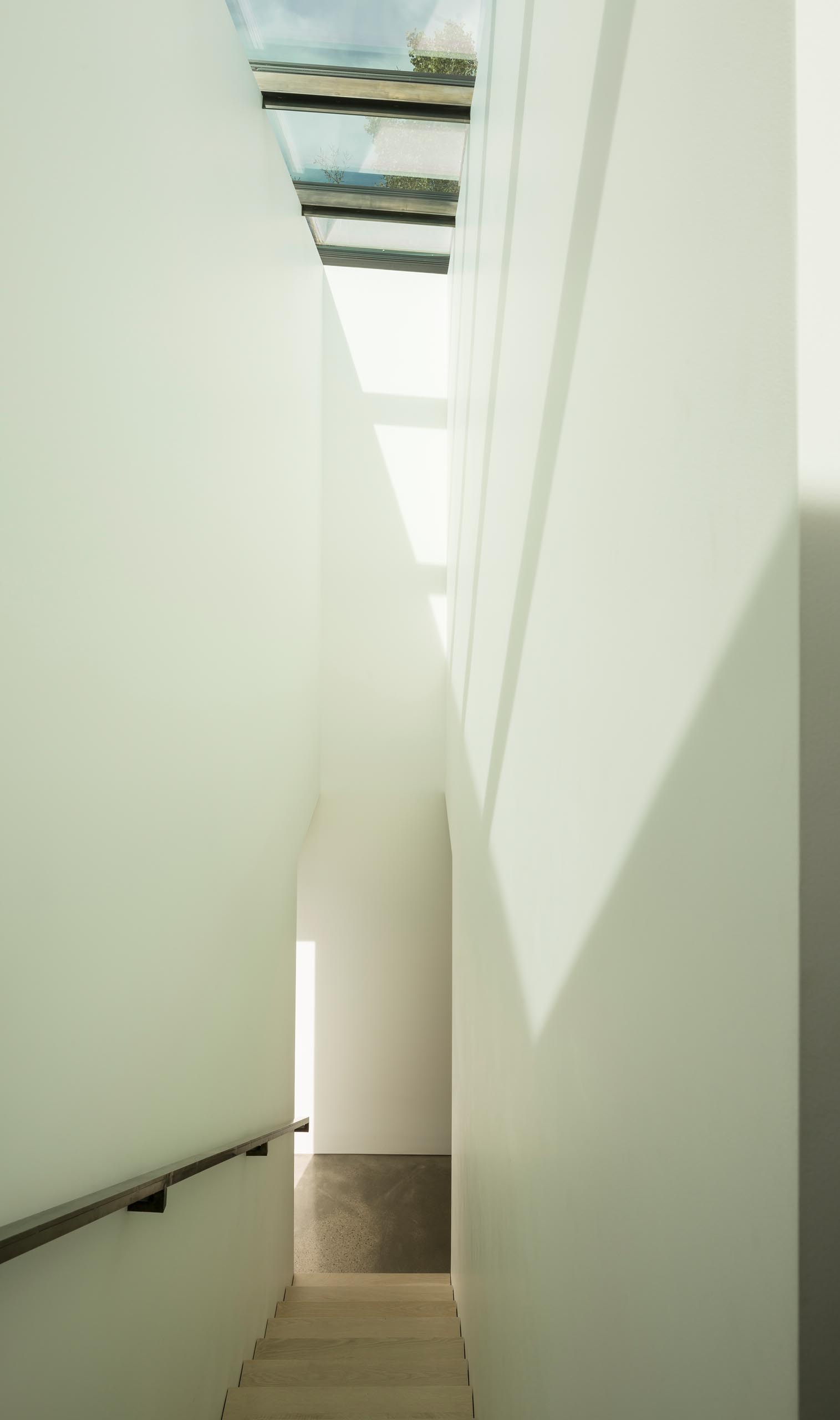 Современная лестница с металлическими перилами и мансардными окнами.