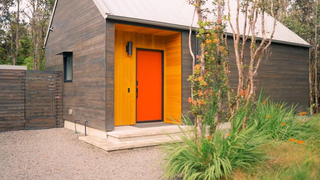 Современный крохотный дом с ярко-оранжевой дверью.