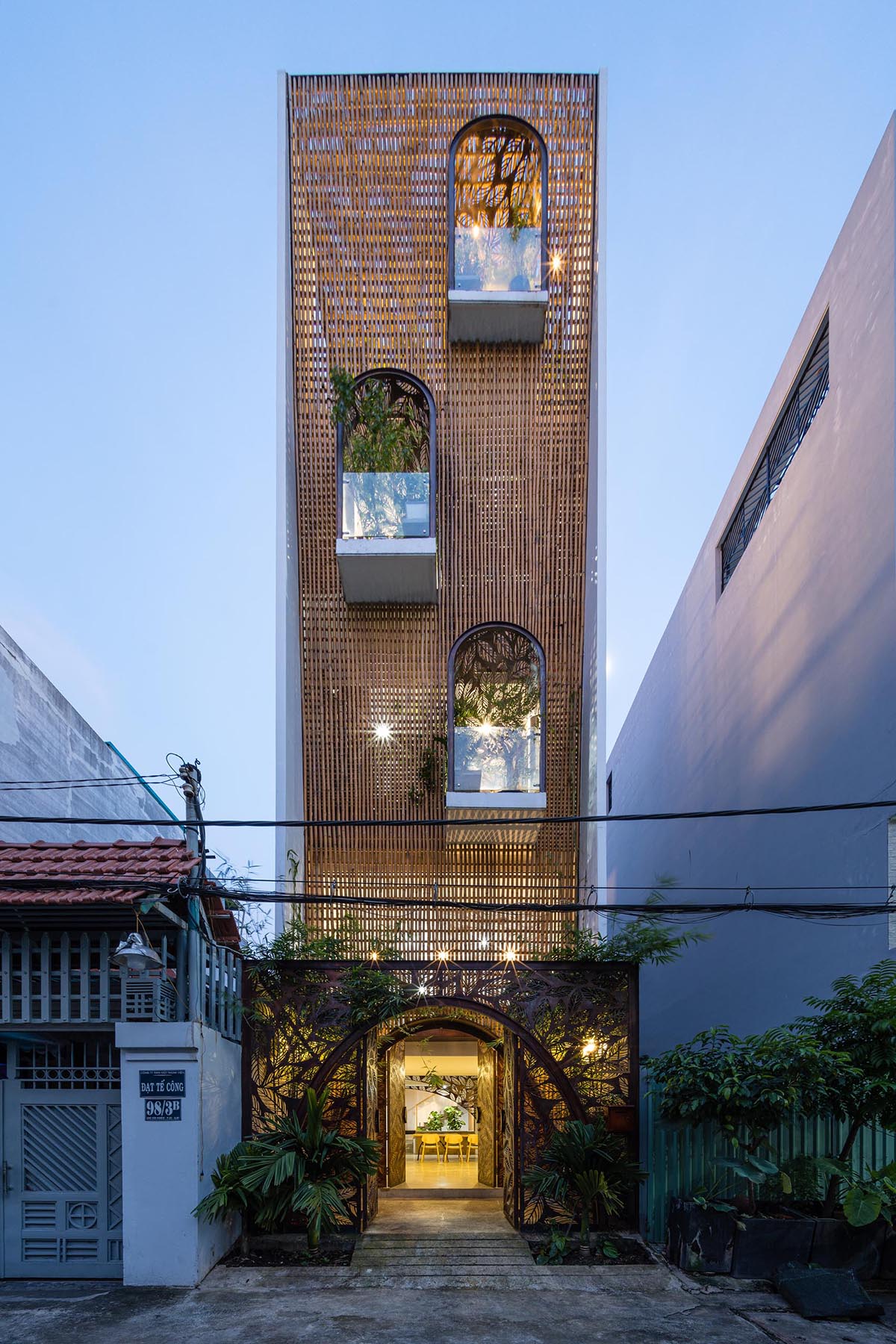 Современный дом во Вьетнаме с декоративными металлическими перегородками с изображением листьев.