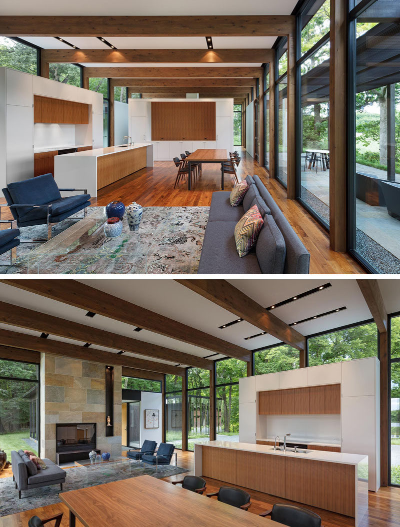 Современный дом с полом из орехового дерева, открытыми деревянными балками, белыми стенами и камином изого камня. # Дизайн интерьера # Дизайн кухни # Камин