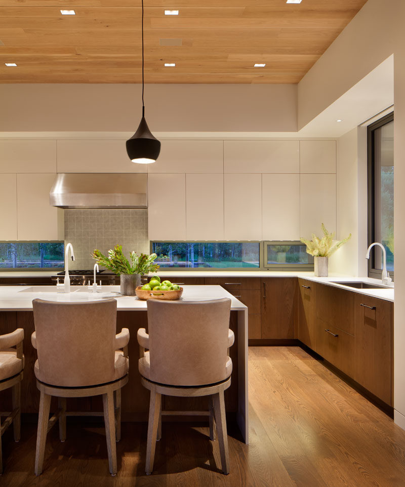  На этой кухне минималистичные белые шкафы, белый остров и белые столешницы были объединены с нижними деревянными шкафами, чтобы создать современный вид. # Кухня # Современная кухня 
