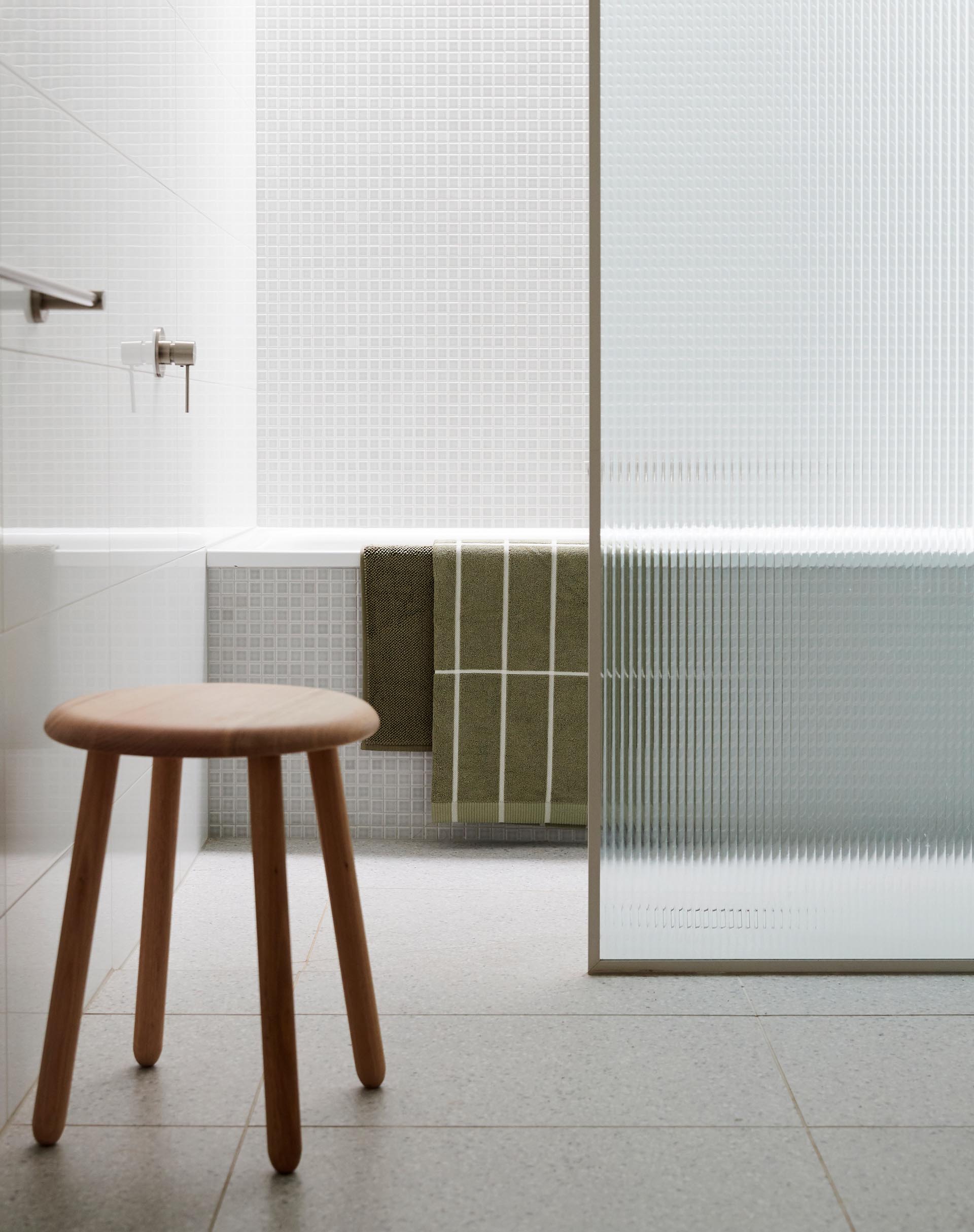 В этой современной ванной комнате маленькие квадратные плитки покрывают стены и внешнюю поверхность ванны.