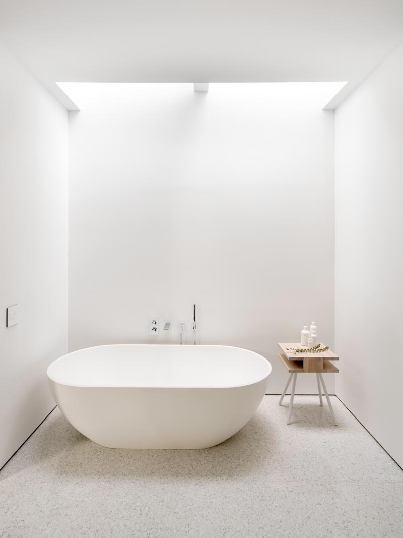 В этой современной главной ванной комнате отдельно стоящая ванна расположена прямо под световыми люками, что позволяет пользователю смотреть в небо во время отдыха. # Ванная # Мастерская # БелаяВанная