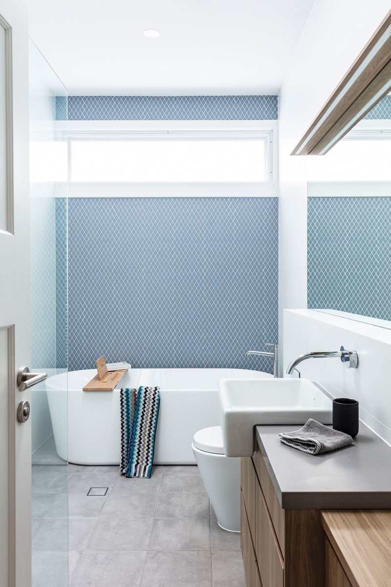 Идеи для ванных комнат - сине-серая плитка была использована для создания акцентной стены в этой современной ванной комнате с отдельно стоящей ванной. # СовременныеВанная # Идеи для ванной # ПлиткаАкцентСтена