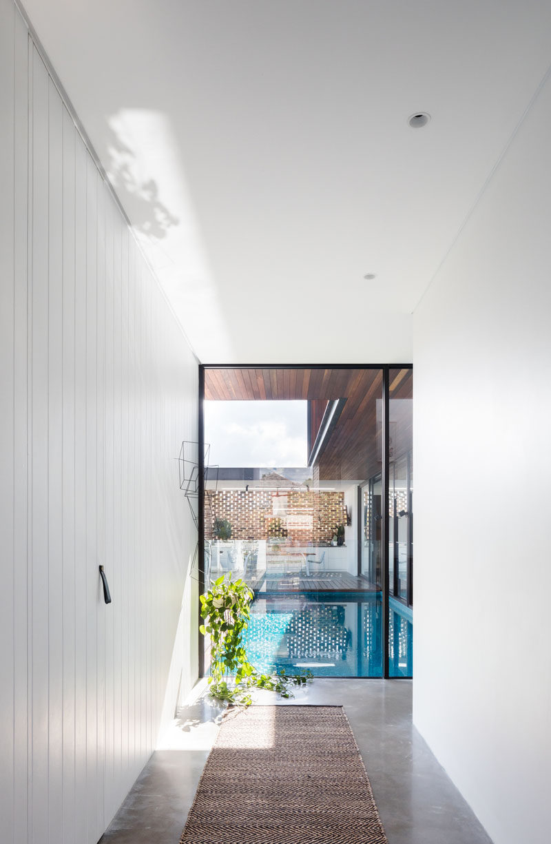 Внутри этого современного дома коридор с ярко-белыми стенами ведет от входа к бассейну и социальным зонам дома. # ИнтерьерДизайн # Прихожая # Окна