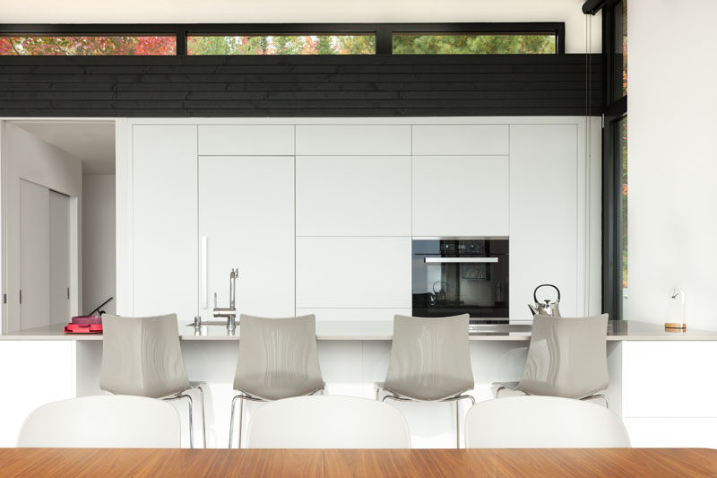  На этой современной кухне белые минималистичные шкафы гармонично сочетаются с белыми стенами и контрастируют с акцентами из темного дерева. #ModernWhiteKitchen #WhiteKitchen #KitchenDesign 
