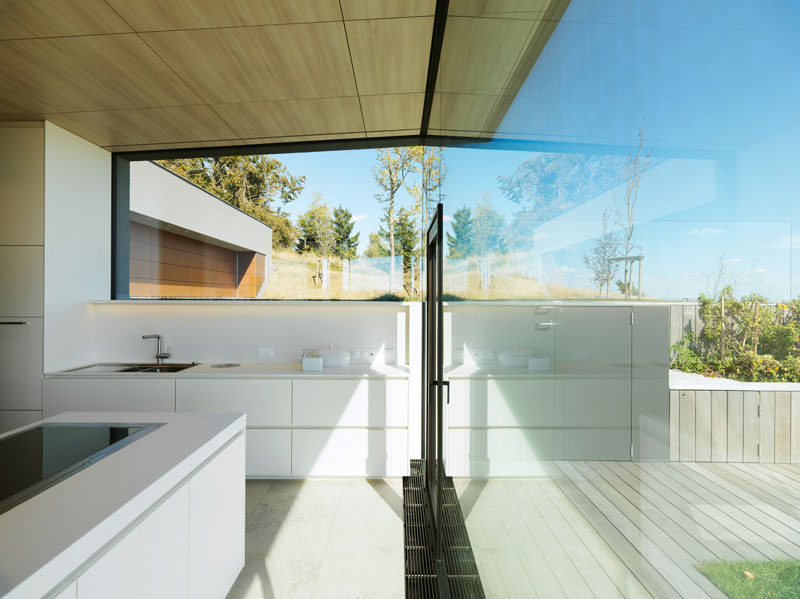 Эта минималистская белая кухня с большими окнами обеспечивает максимальный вид и естественный свет. # БелаяКухня # Окна # СовременнаяКухня