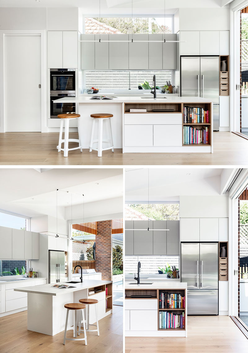 Идеи для кухни - на этой современной кухне минималистичные белые шкафы расположены заподлицо со стенами, а остров обеспечивает дополнительное пространство для стойки и открытые стеллажи для книг с рецептами. #KitchenIdeas # ModernKitchen #KitchenDesign #KitchenIsland
