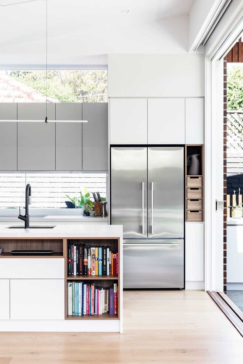 Идеи для кухни - на этой современной кухне минималистичные белые шкафы расположены заподлицо со стенами, а остров обеспечивает дополнительное пространство для стойки и открытые стеллажи для книг с рецептами. #KitchenIdeas # ModernKitchen #KitchenDesign #KitchenIsland