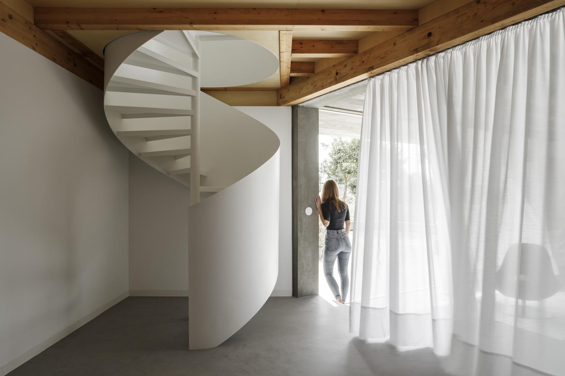 Современный дом с белой винтовой лестницей.