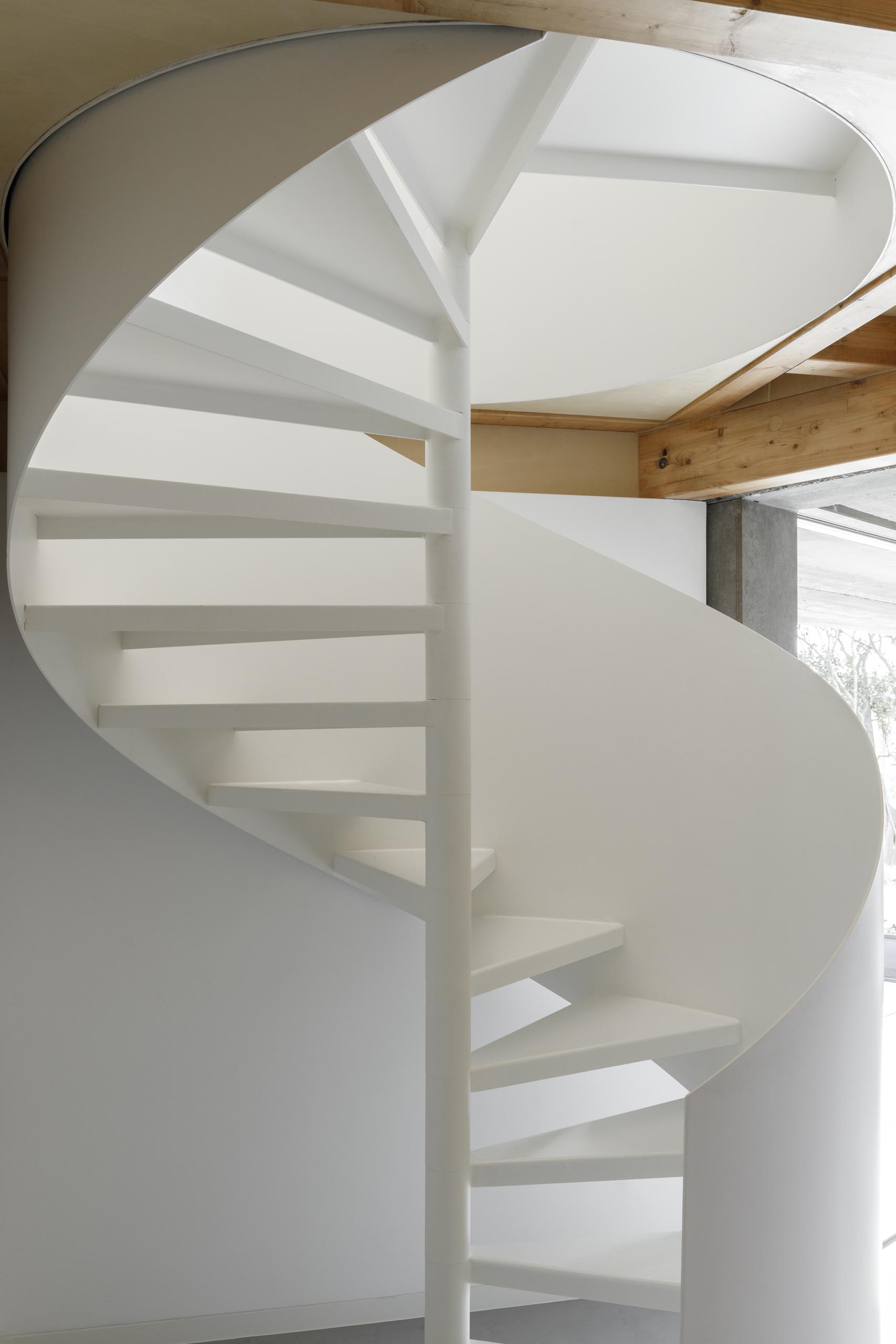 Современный дом с белой винтовой лестницей.