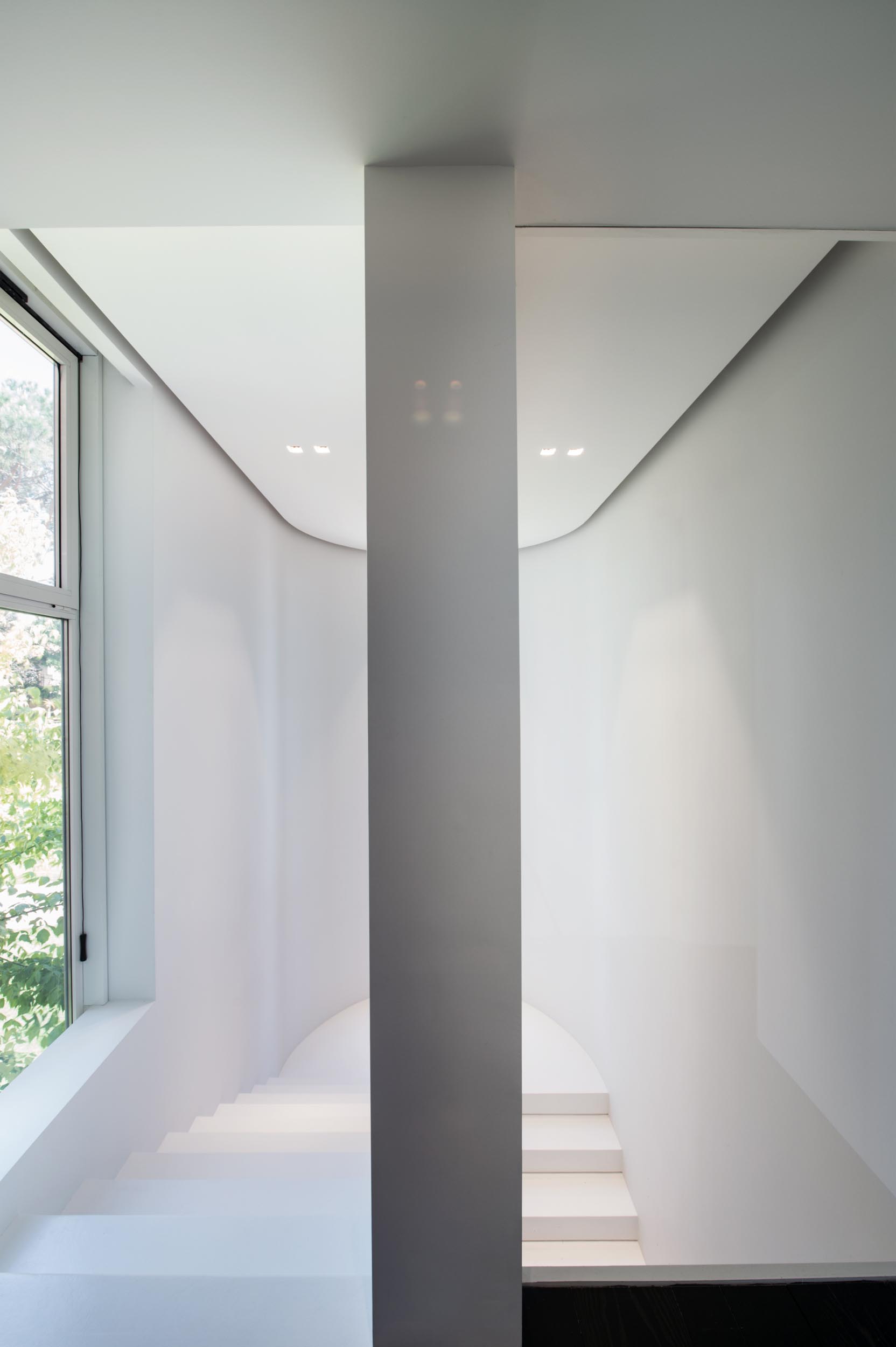 Белая лестница, которая помогает сохранить яркость пространства, а встроенные перила также имеют скрытое от глаз светодиодное освещение.