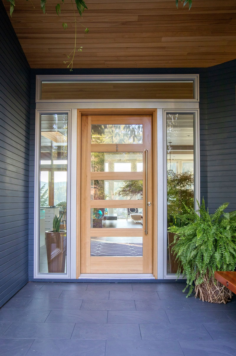  Входная дверь из дерева и стекла, окруженная дверь, приветствует посетителей дома. # Передняя дверь # Современные 