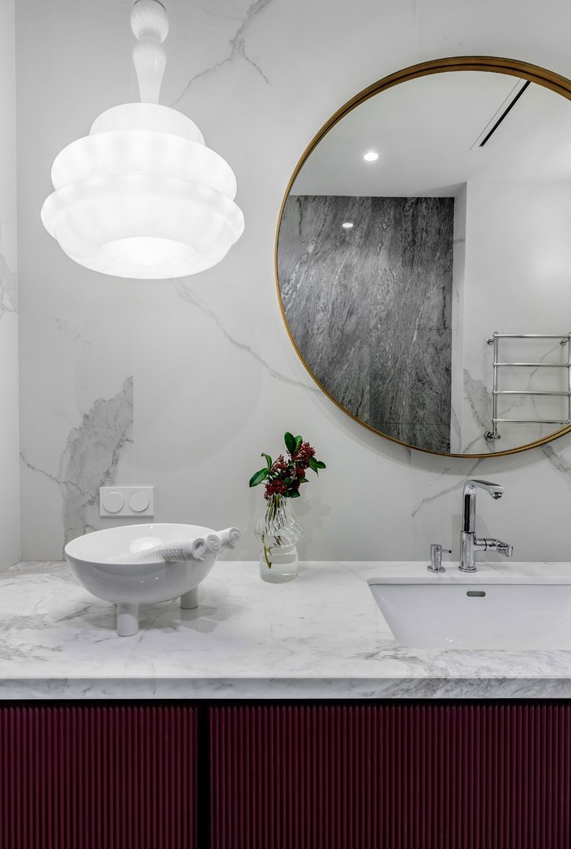 В этой современной ванной комнате серый мрамор покрывает стены и туалетный столик, а подвесной светильник Novecento от Vistosi висит рядом с круглым зеркалом. # Современная ванная # Дизайн ванной # СерыйВанная
